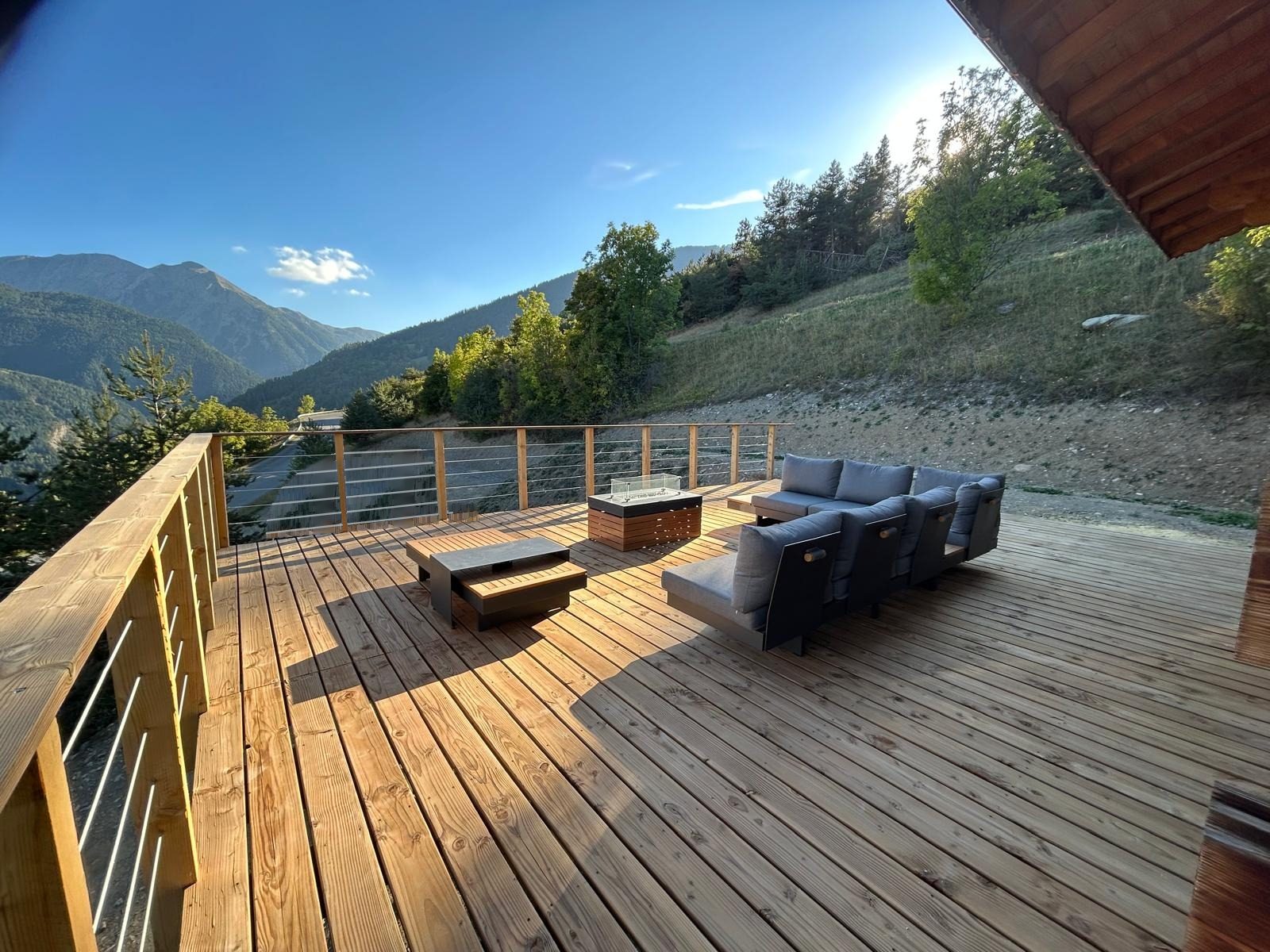 La terrasse du chalet et son salon extérieur, face aux montagnes de l'Ubaye